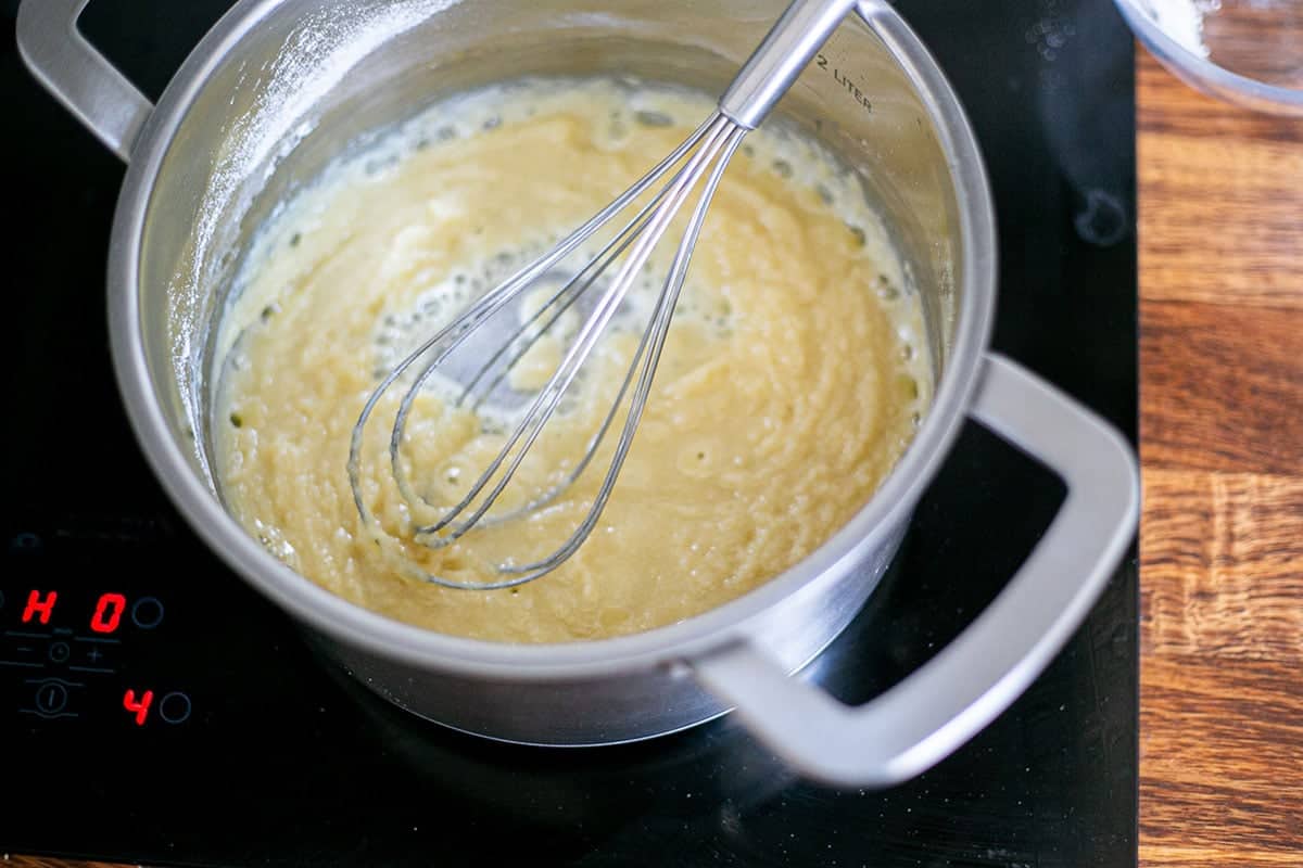 The roux for besciamella in a pot with a whisker.
