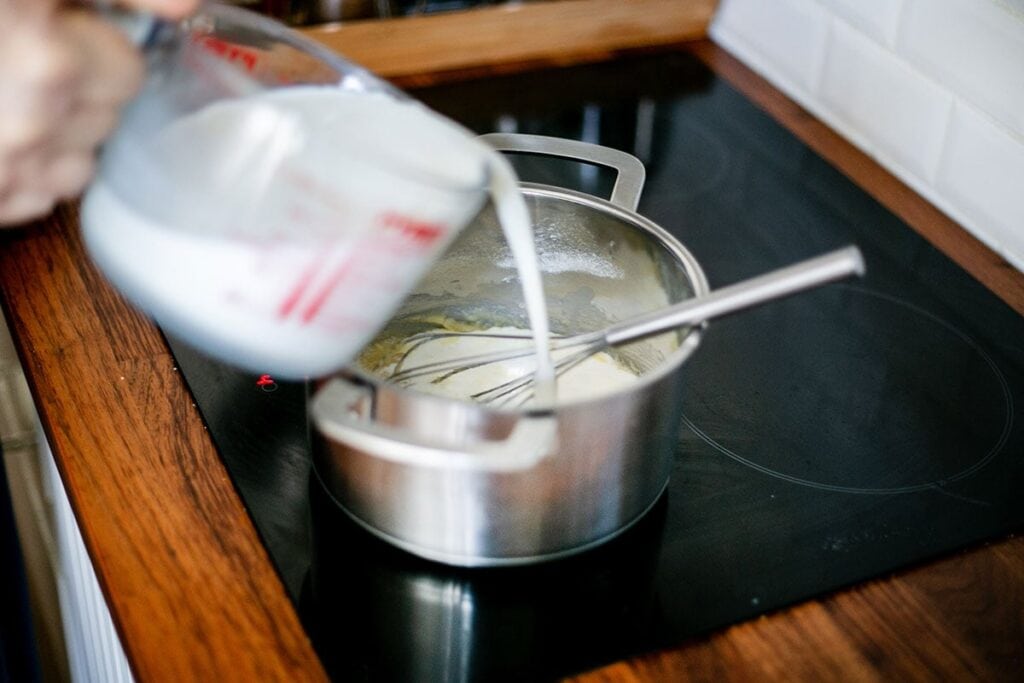 Adding the milk to the pot.