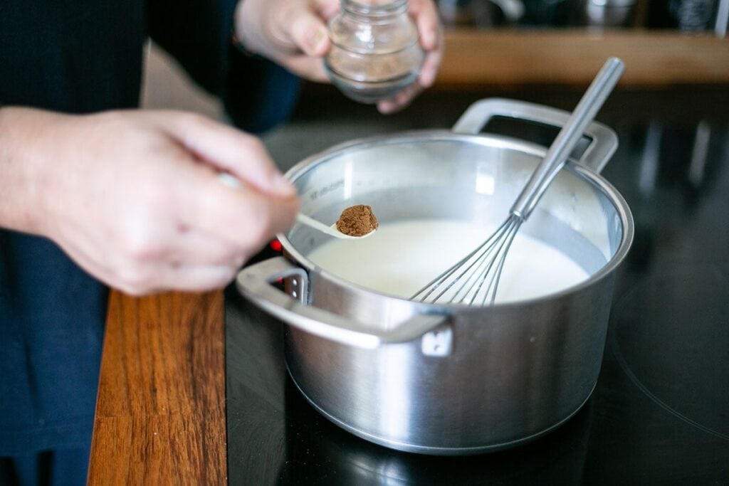 Adding the nutmeg to the sauce.