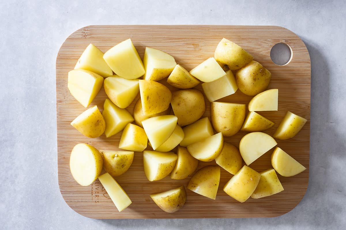 A cutting board with potatoes