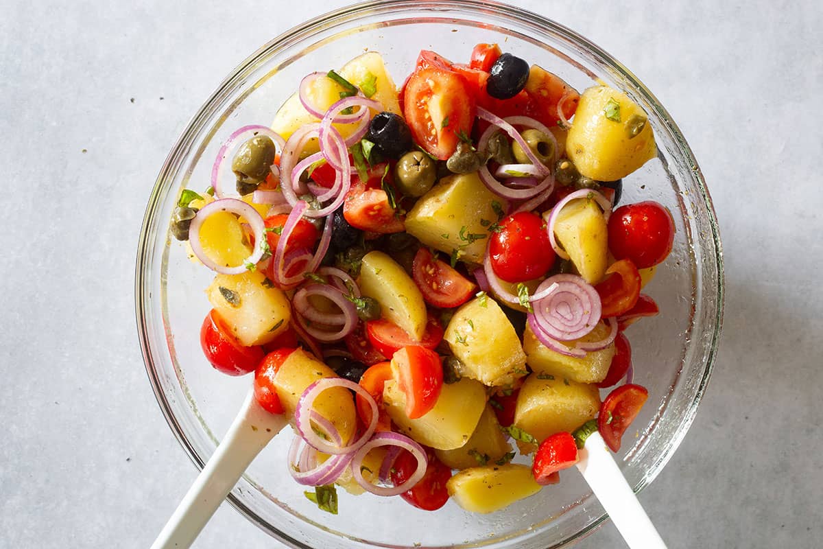 Mixing the insalata pantesca in the bowl.