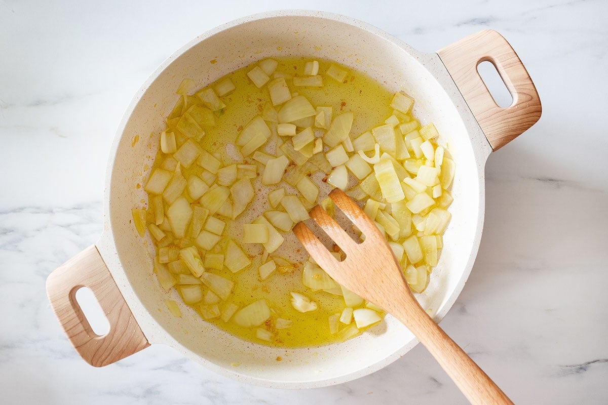Sautéing onion and garlic in a pan.