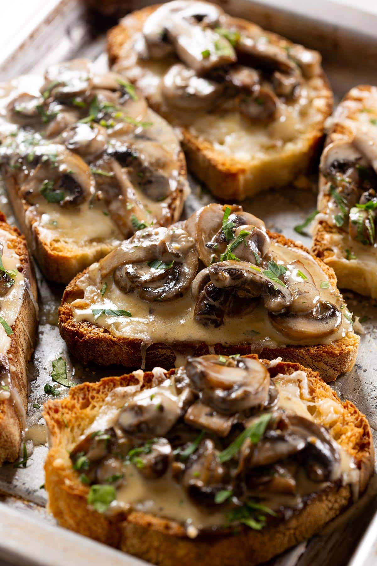 Bruschetta con funghi, also known as creamy mushroom bruschetta, on a baking tray.