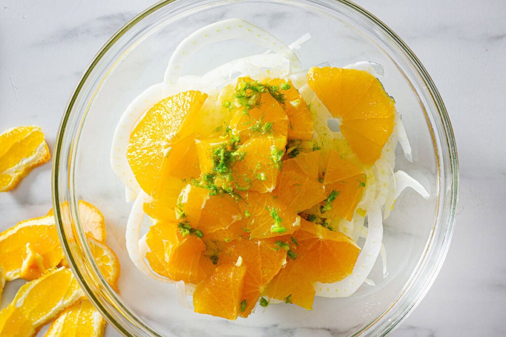 The dressing added to the bowl of sliced fennel and oranges.