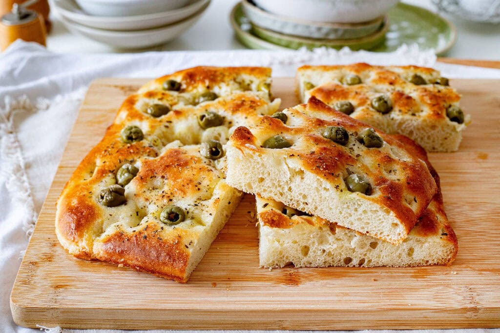 Focaccia con le olive on a cutting board.