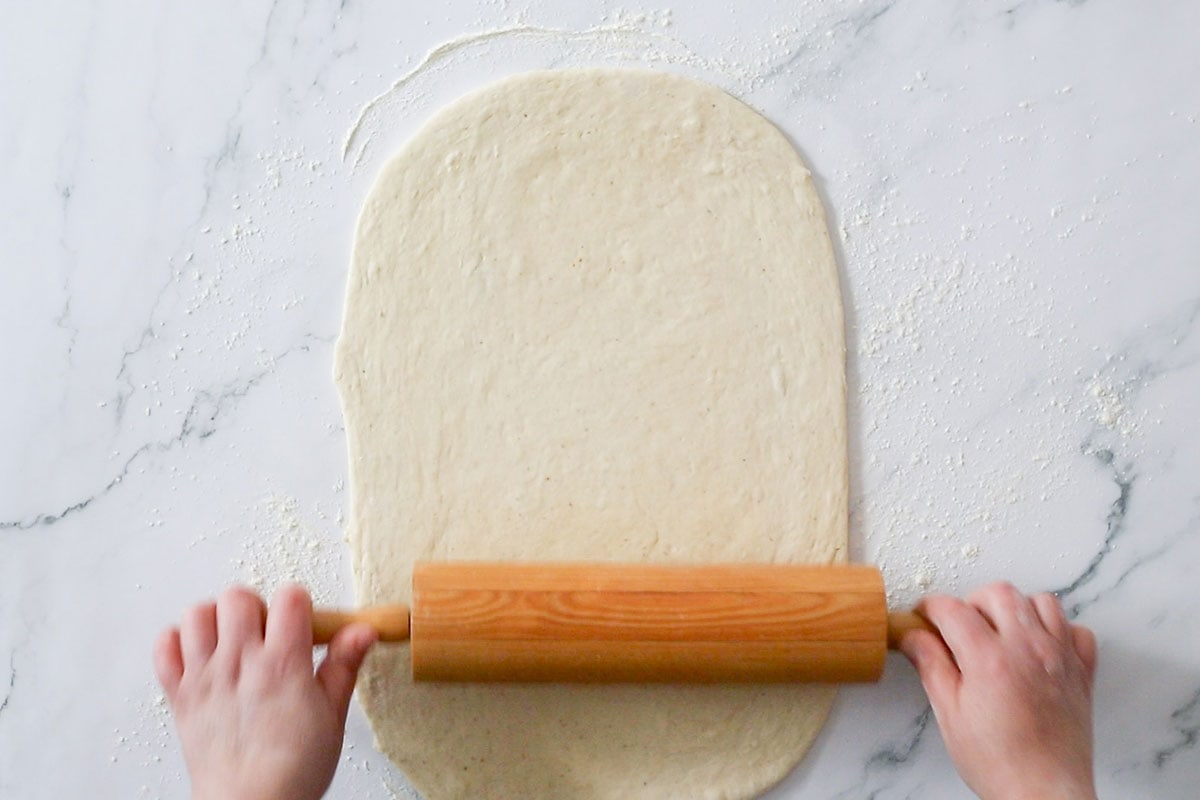 Rolling the dough with a rolling pin.