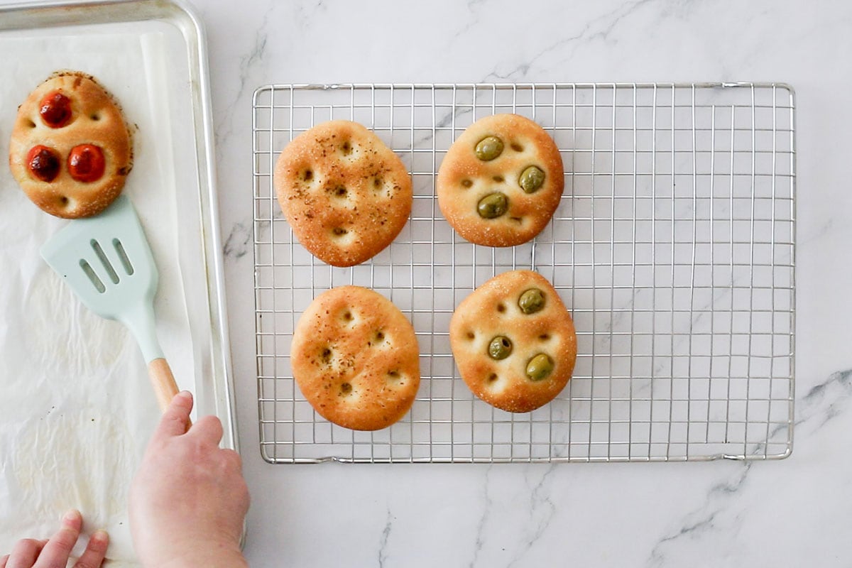 Transferring the baked focaccine to a cooling rack.