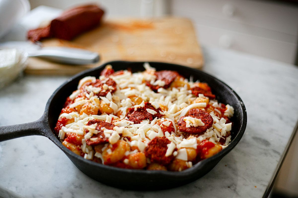 Gnocchi with nduja and mozzarella before baking, in a skillet.