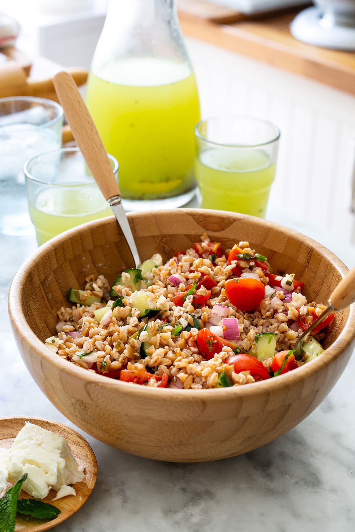 Insalata di farro in a wooden bowl with a spoon.