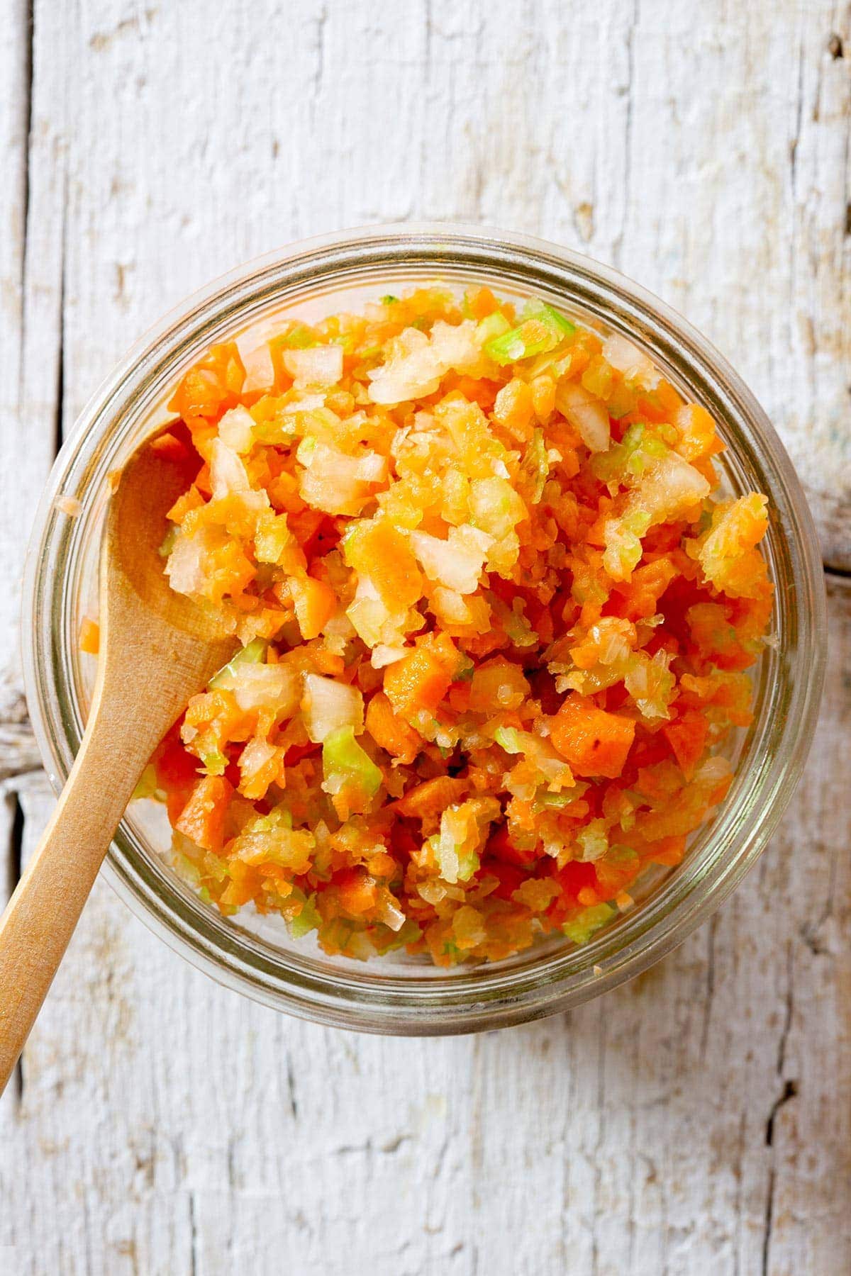 Italian soffritto in a jar with a small wooden spoon.