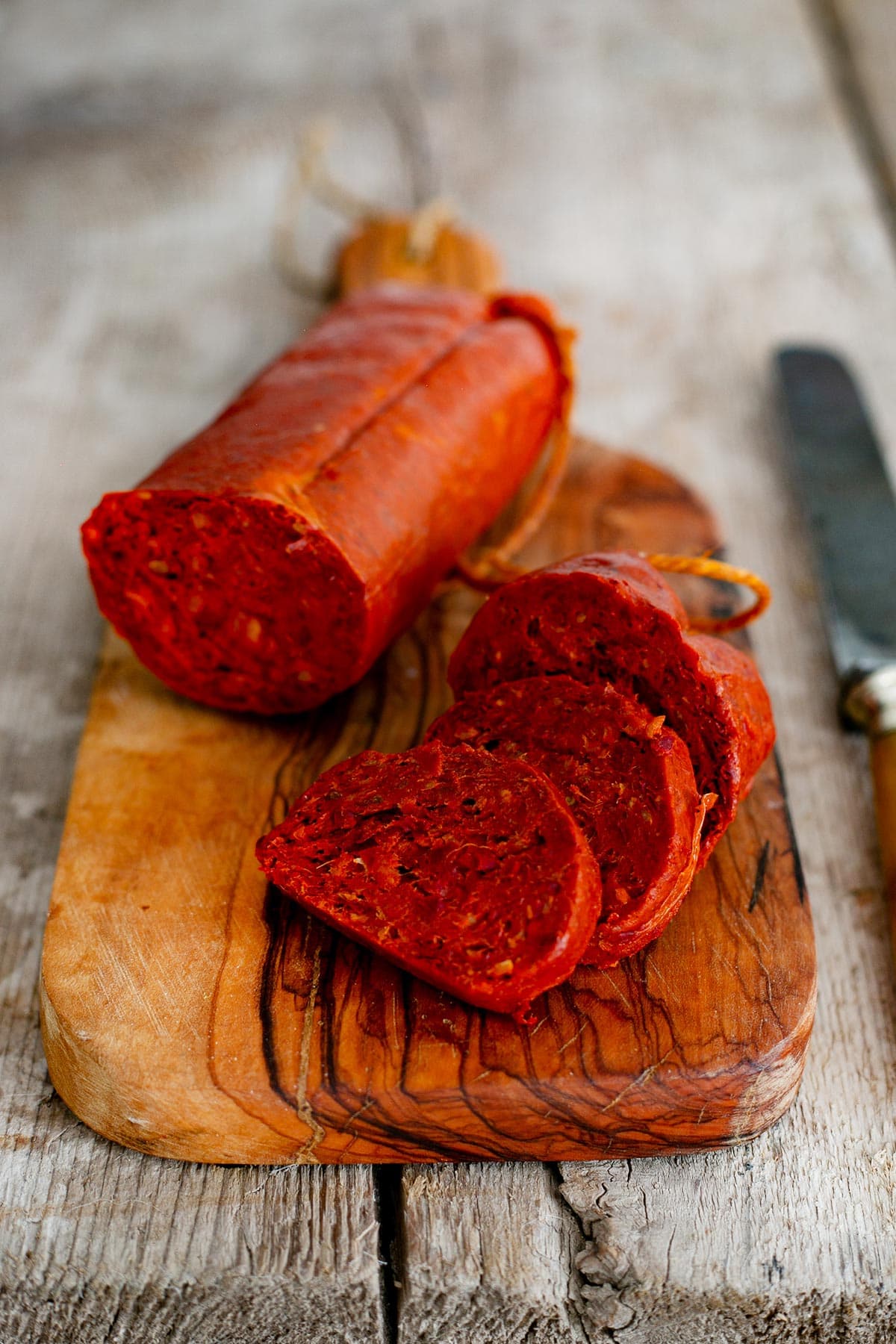 Nduja sausage sliced on a cutting board.