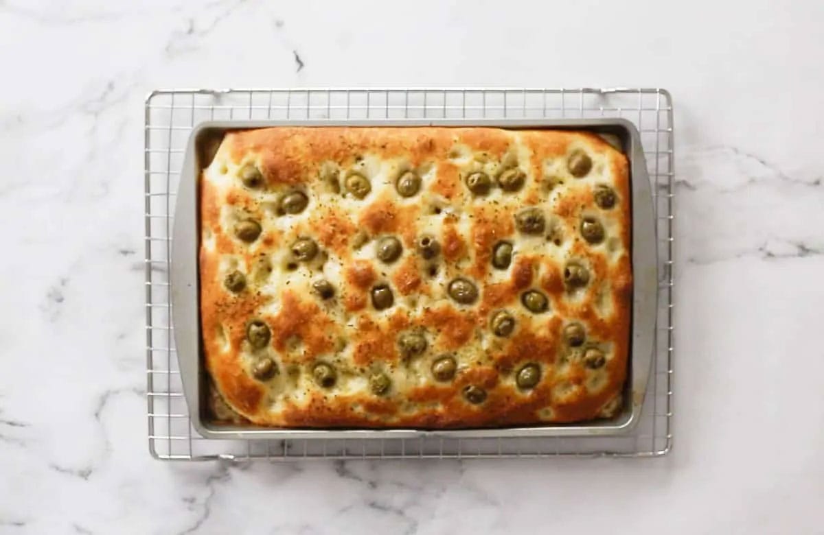 Focaccia freshly baked on a cooling rack.
