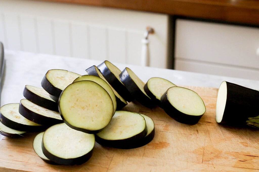 Sliced eggplant on a cutting board.
