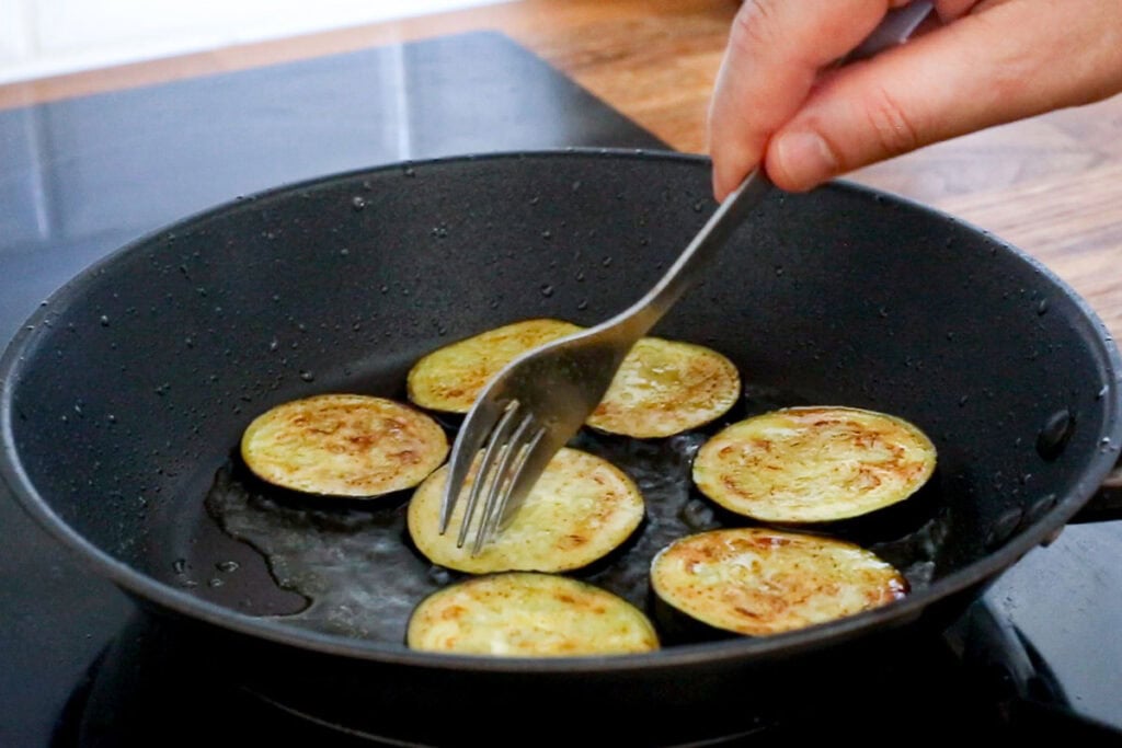 Frying slices of eggplant in a pan.