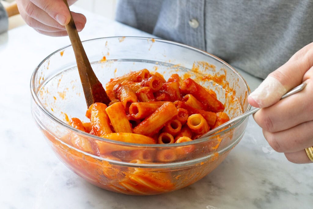 Coating rigatoni pasta con sugo alla Norma.