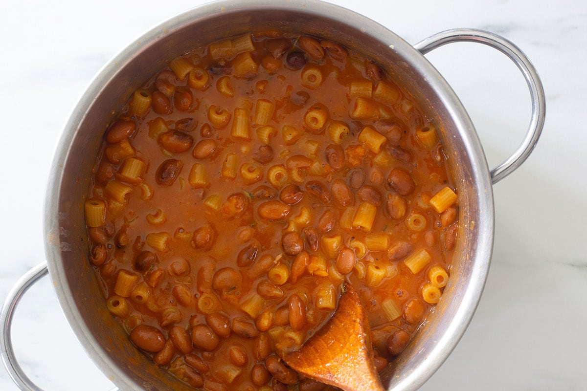 Cooking pasta e fagioli in a pot.
