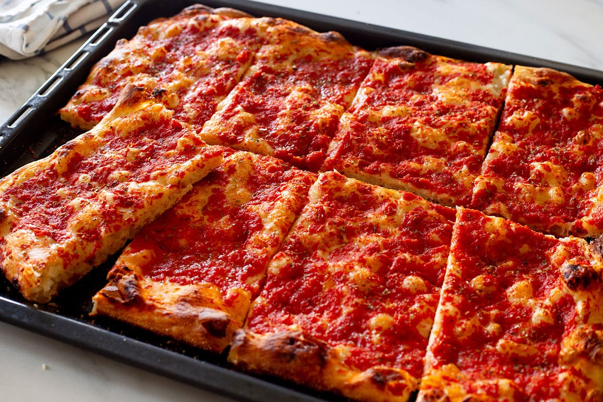 Pizza rossa romana cut on a baking sheet.