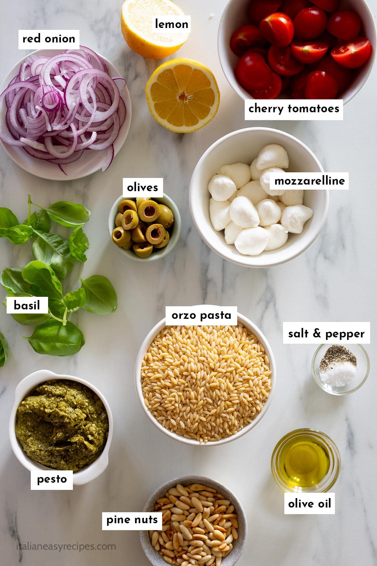 Ingredients for the orzo pesto salad on a kitchen surface with name overlay.