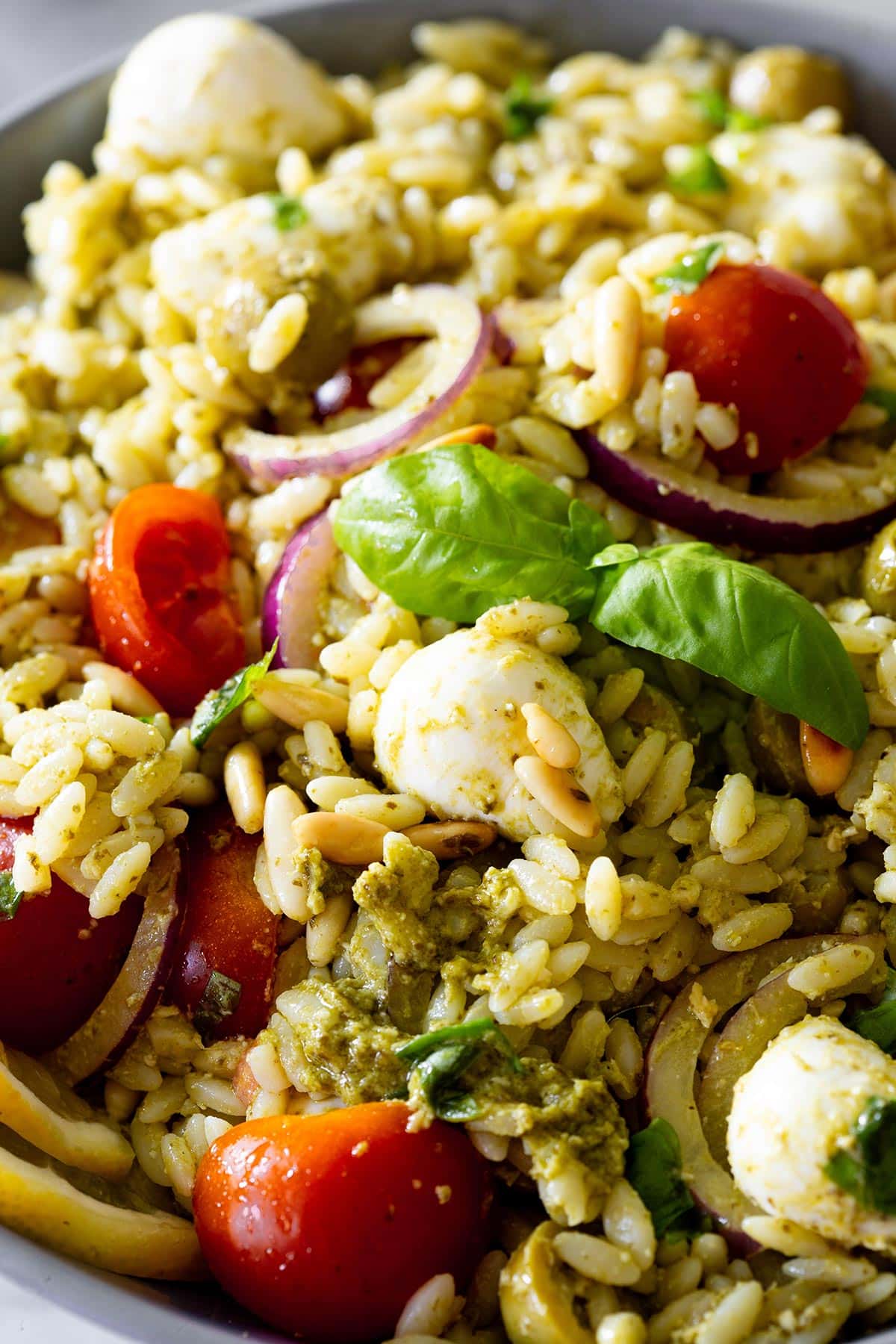 Close-up of orzo pasta salad with pesto.