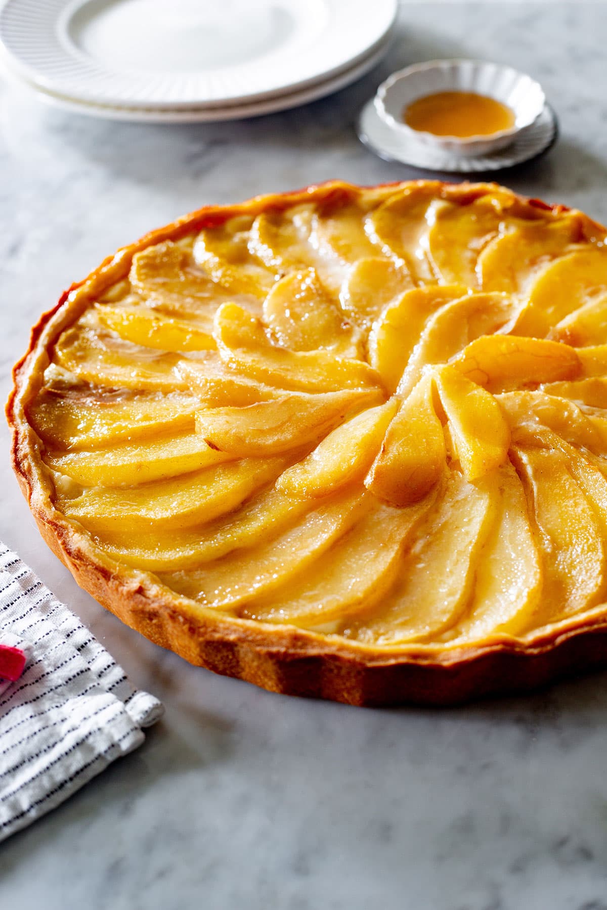 Pear crostata di pere on a marble kitchen countertop.