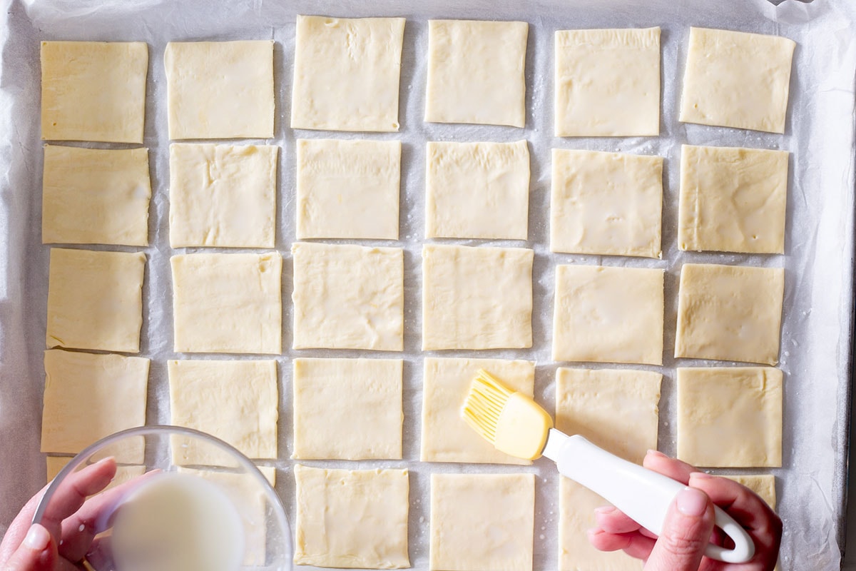 Brushing with milk puff pastry squares.