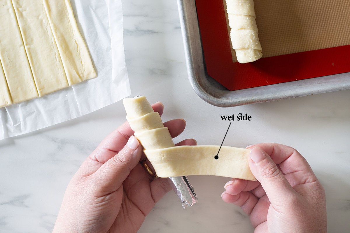 Wrapping a strip of dough on a foil mold.