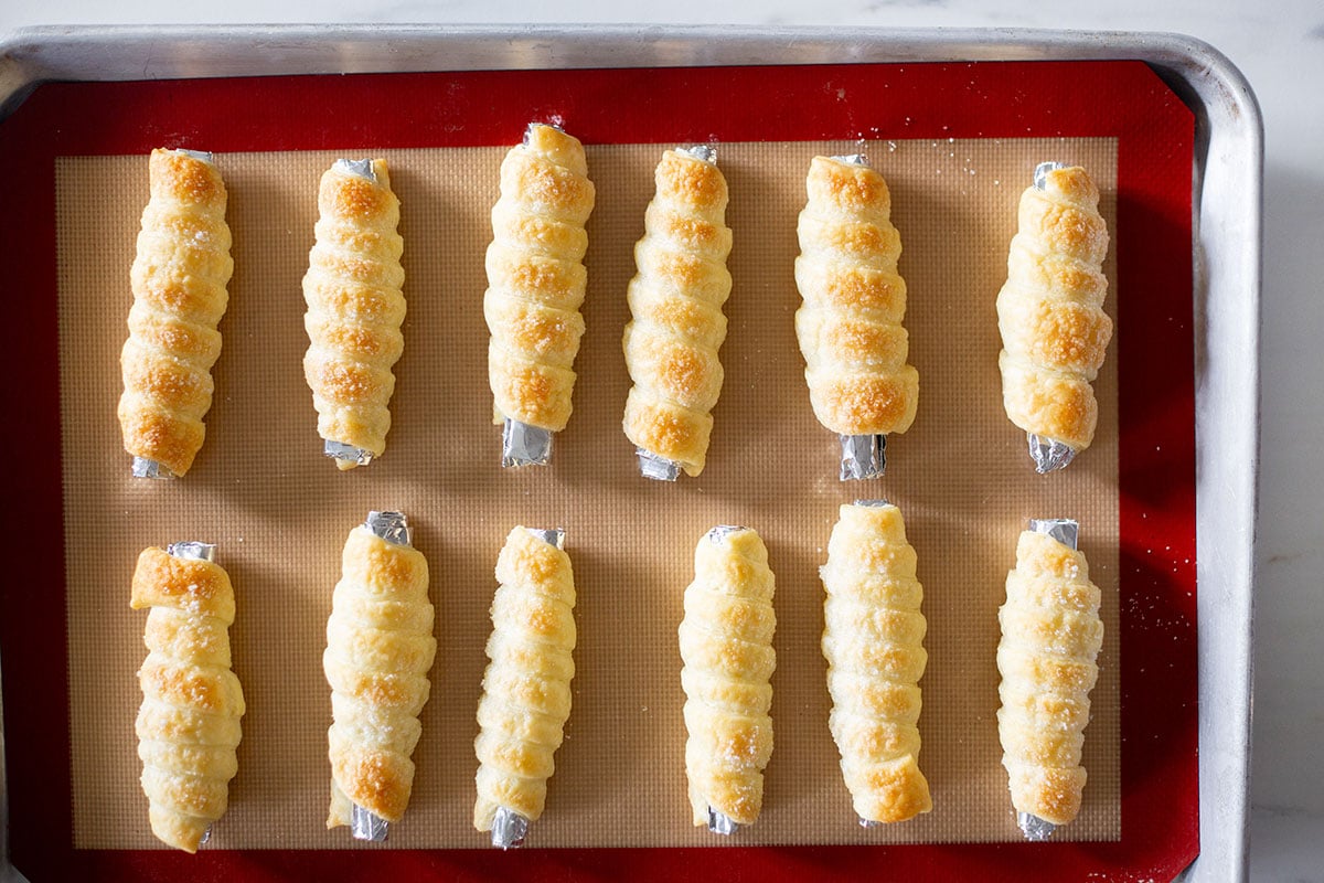 Baked puff pastry dough cannoncini on a baking tray.