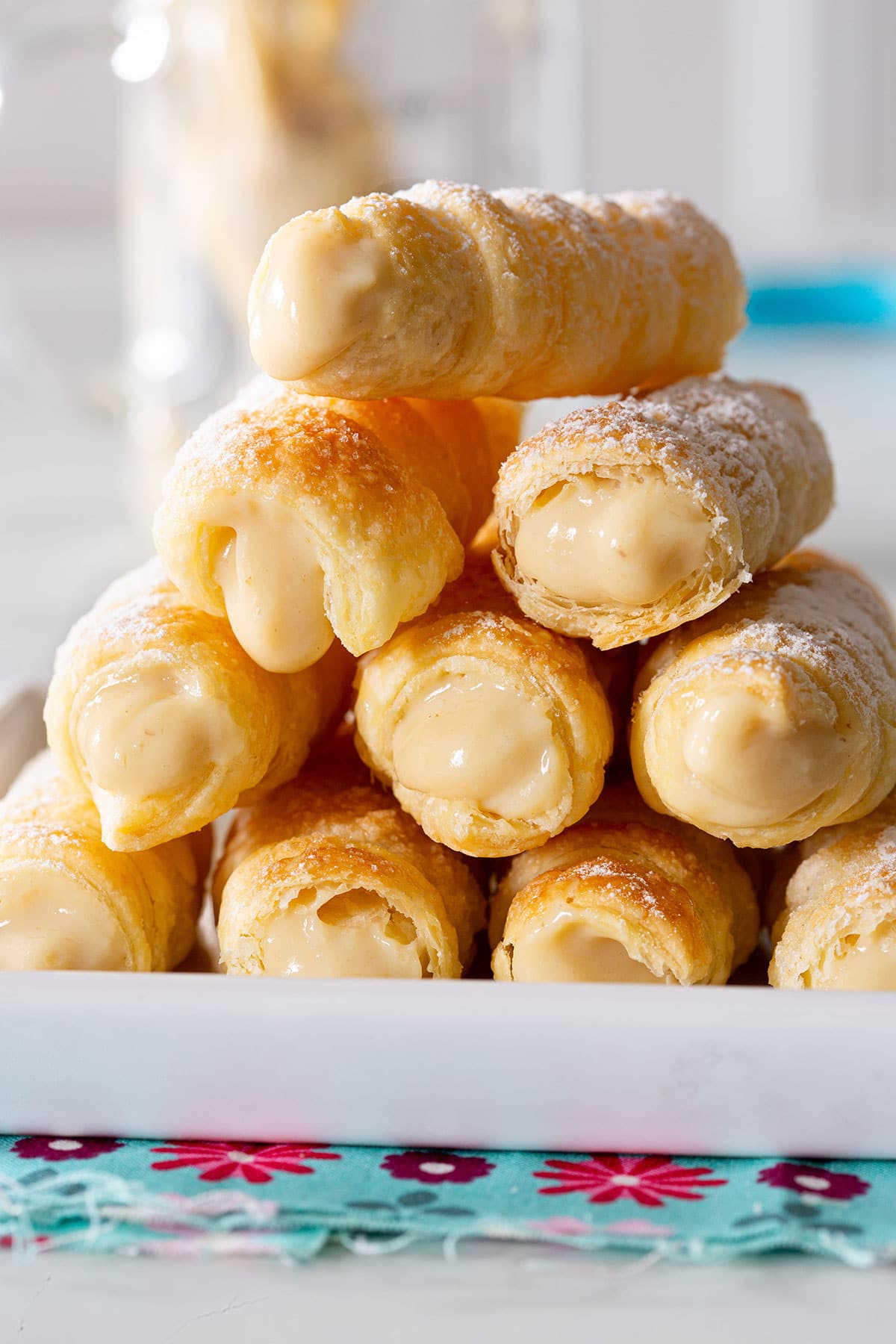 Cannoncini alla crema pastries piled on a white plate.