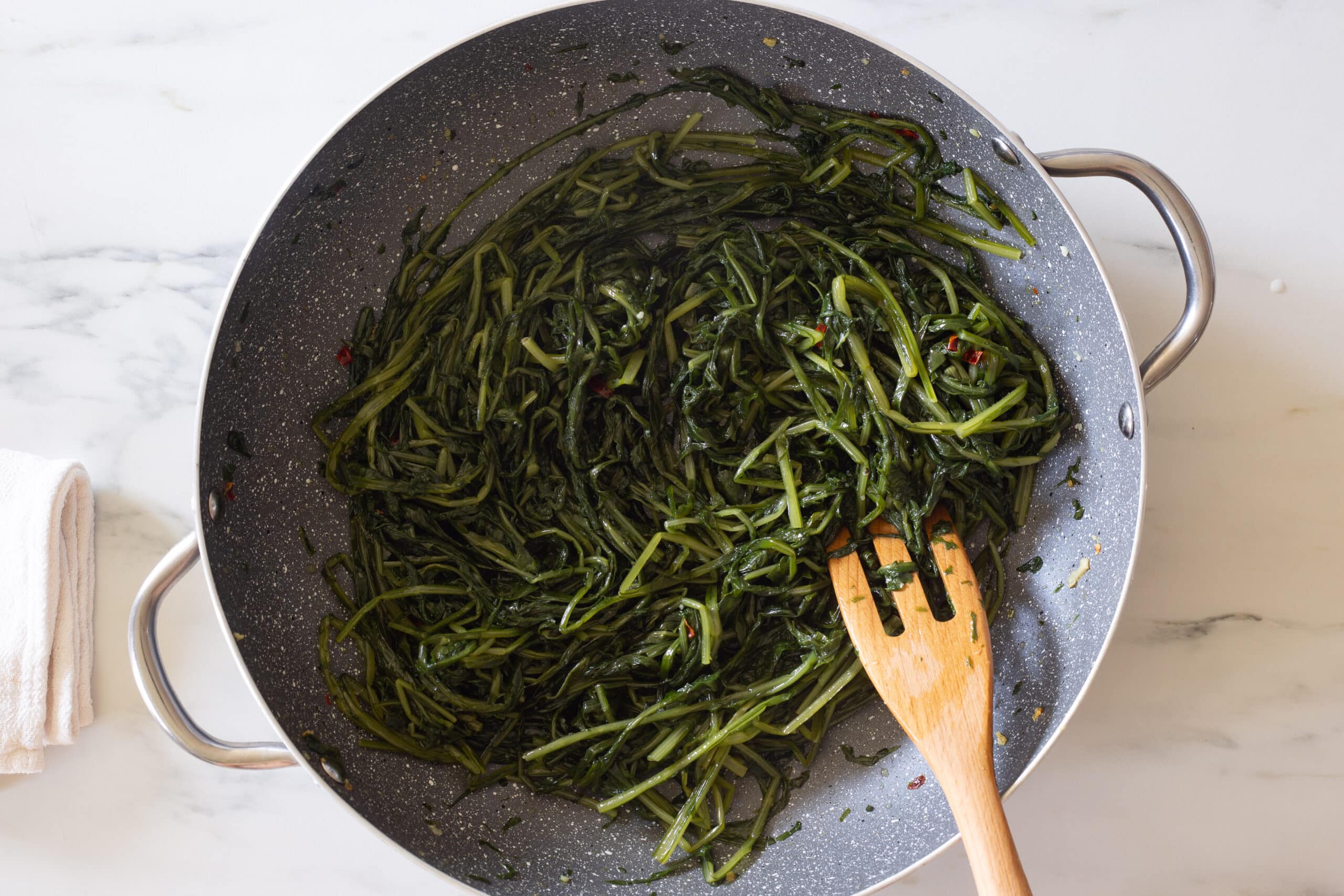 Cooking cicoria ripassata in a pan.