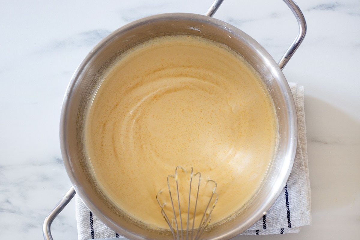 Mixing flour, sugar, and egg yolks in a pot.