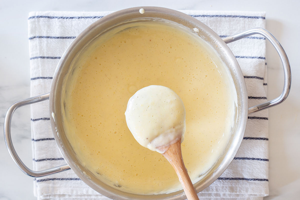 Showing the back of a wooden spoon completely coated with the cream.