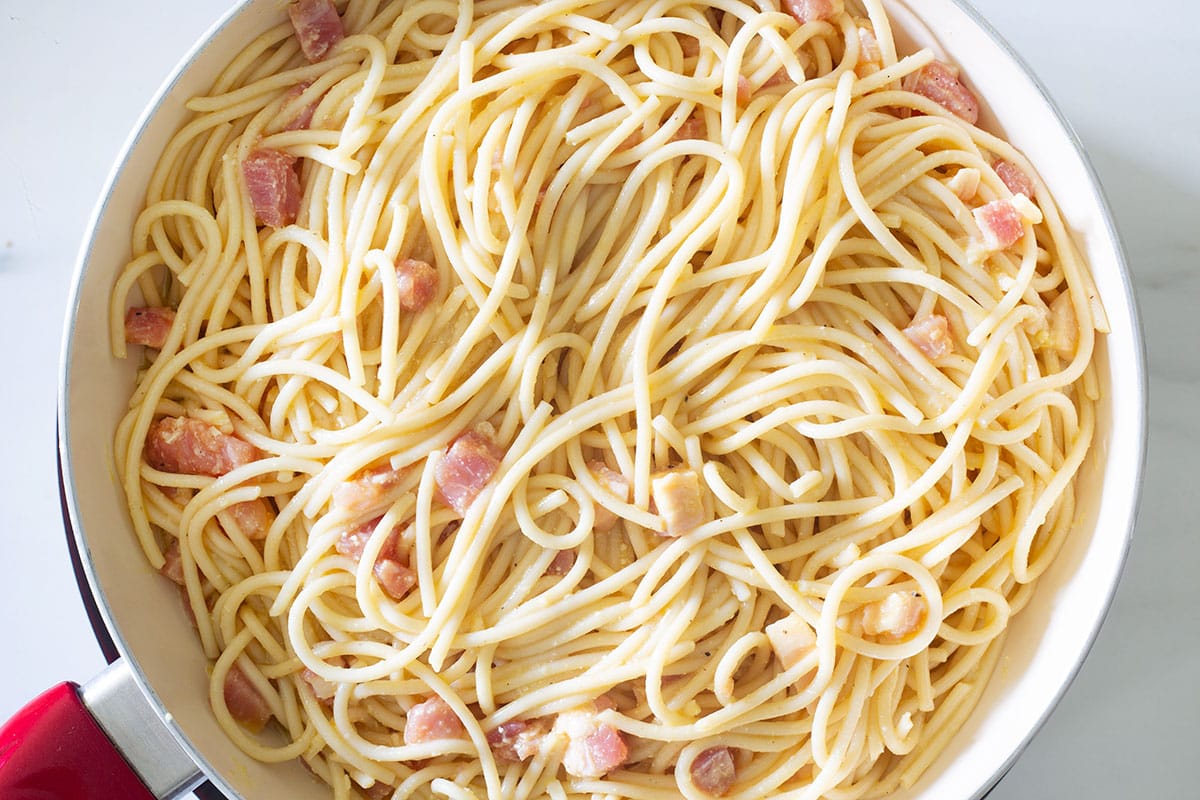 Spaghetti and eggs mixture in a pan.