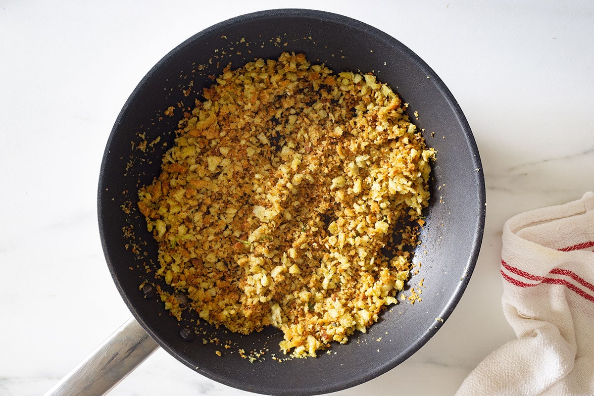 The breadcrumbs and herbs golden and crispy in a small pan.