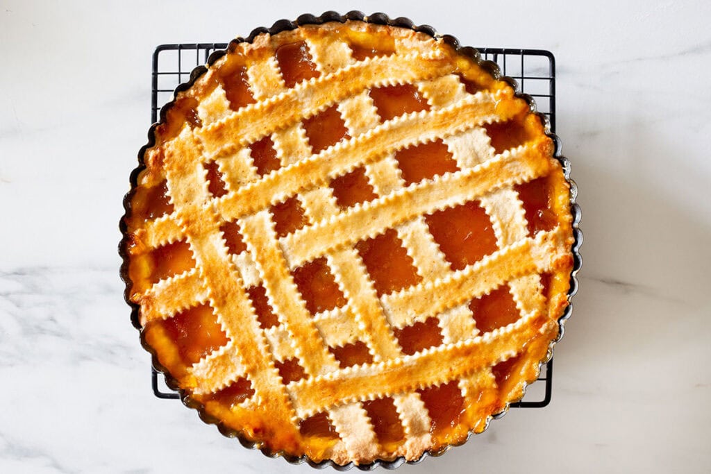 Crostata di marmellata cooling on a rack.