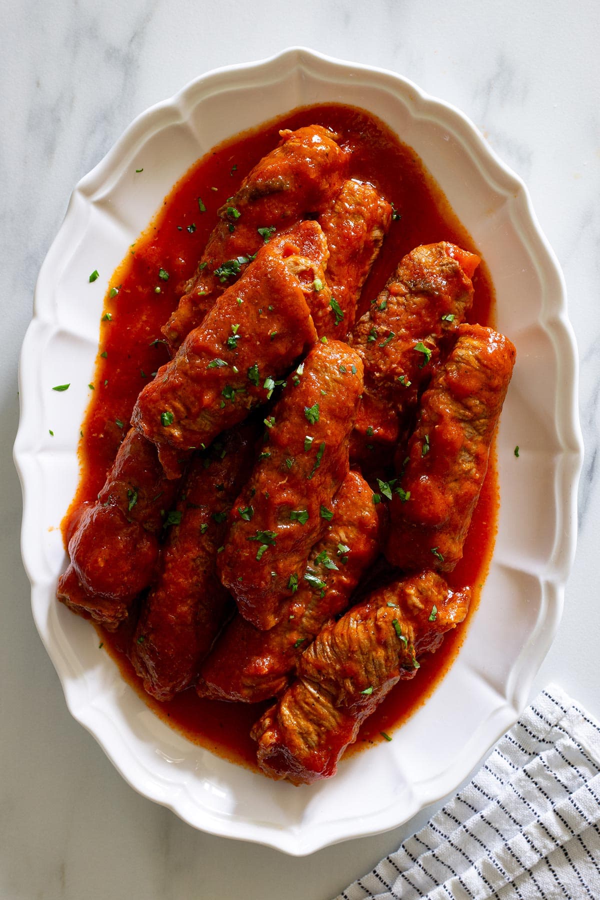 Involtini alla Romana in a platter, garnished with parsley.