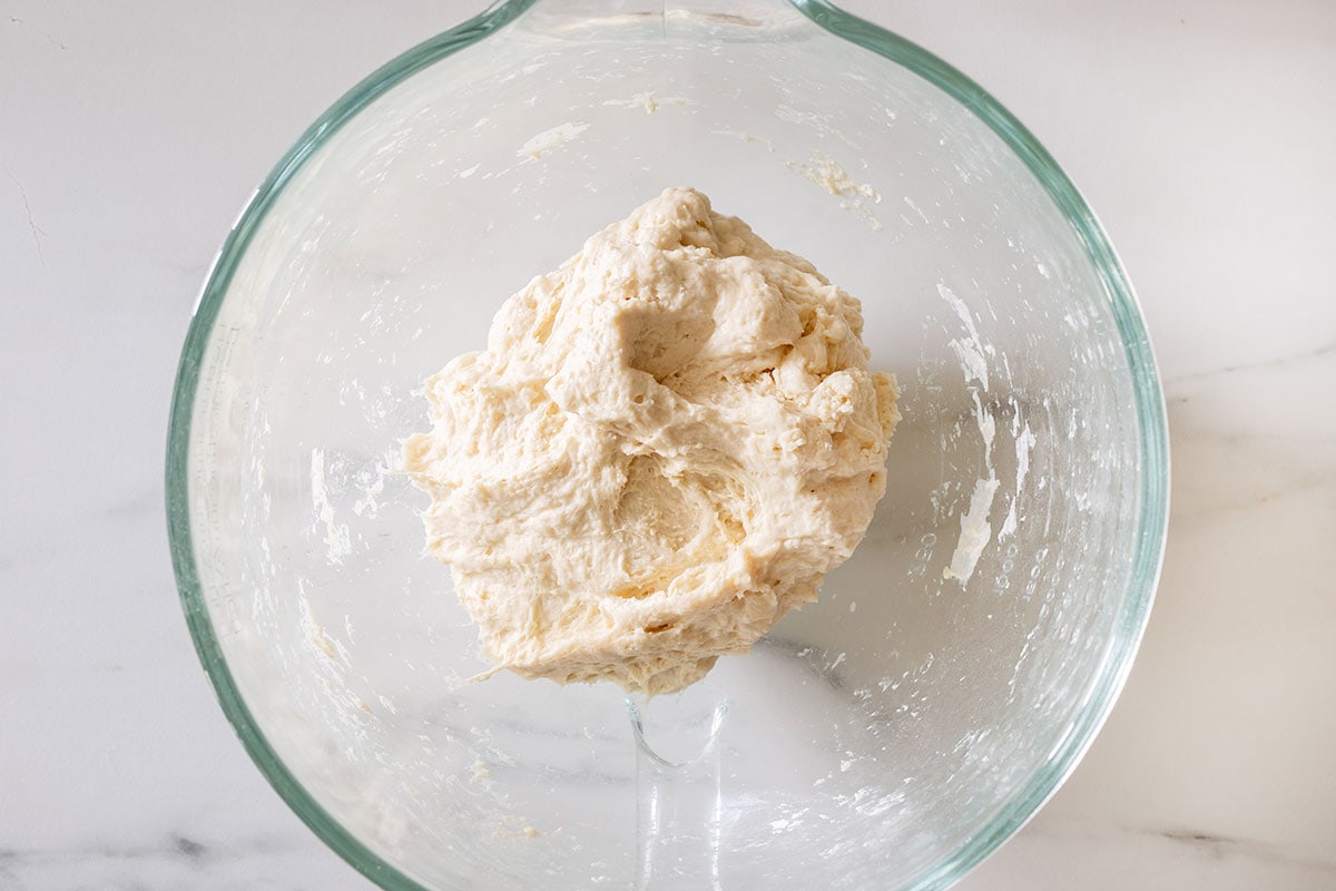 The dough inside a bowl.