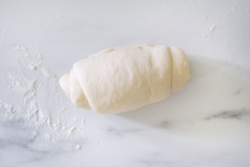 A panino roll shaped on a kitchen surface.