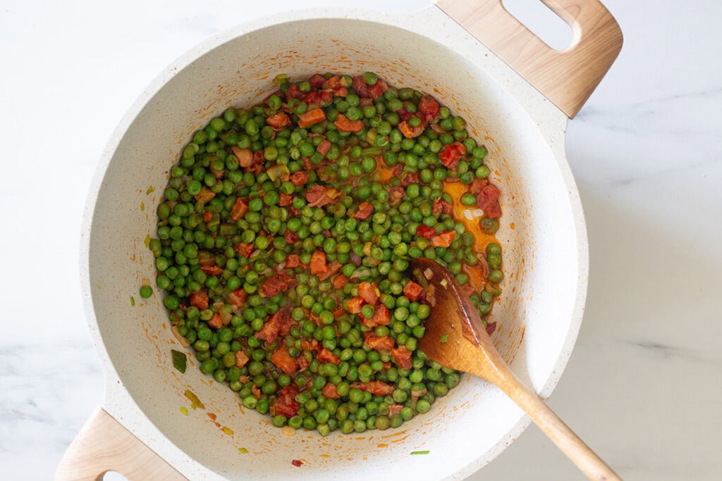 Sautéing peas with bacon, onion, and tomato sauce.