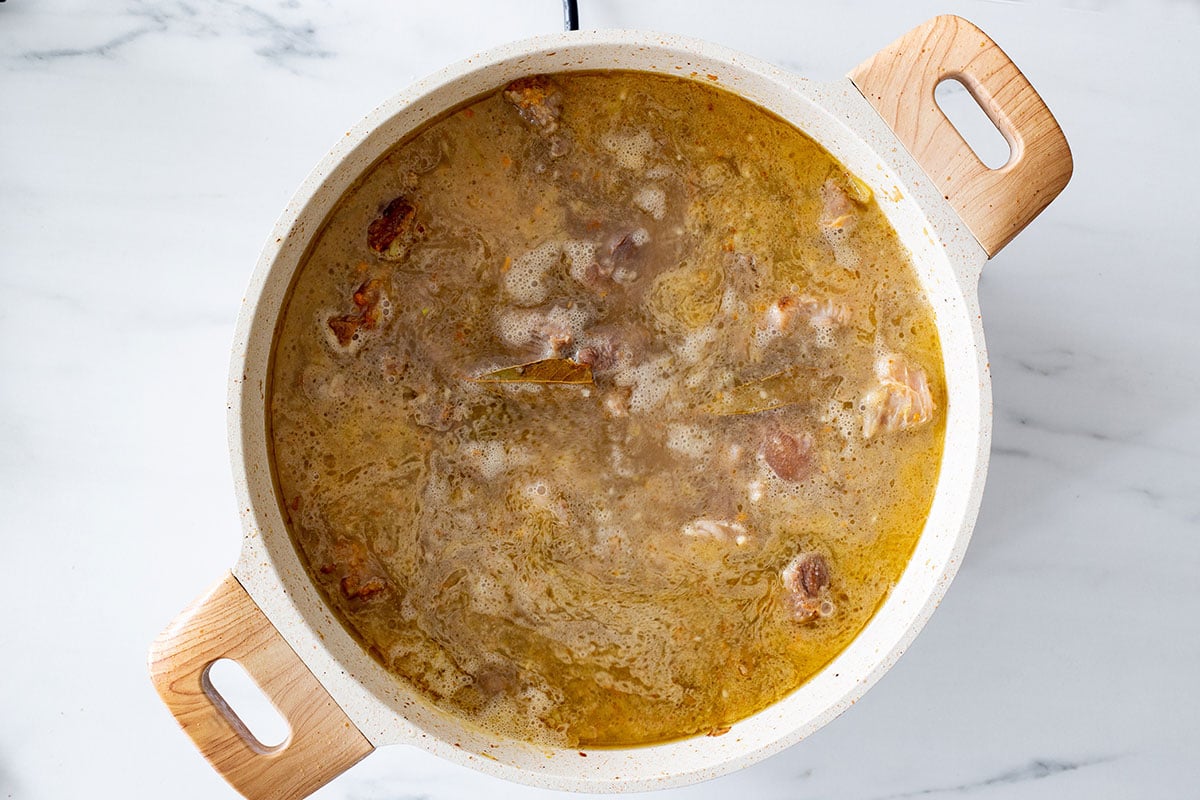 Meat covered with liquid and starting to simmer.
