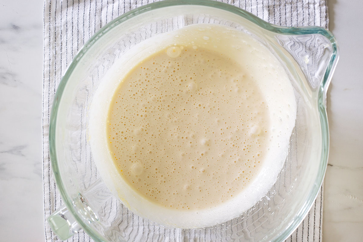 A fluffy and pale mixture of eggs and sugar in a bowl.