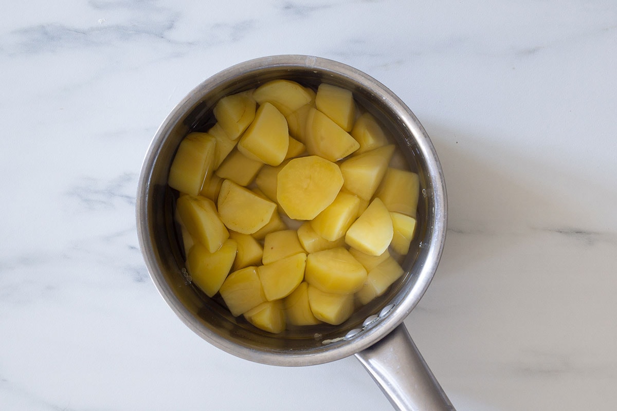 Potato chunks cooked in a small pot.
