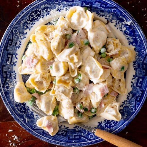 Tortellini alla panna in a plate with a fork.