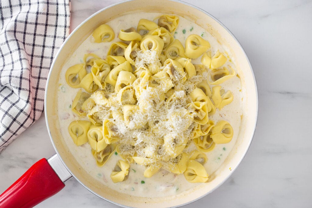 Cooked tortellini added to the pan with the panna sauce.