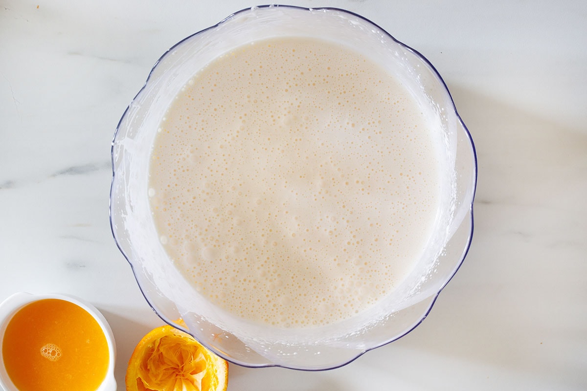 The mixture of fluffy and pale eggs and sugar in a bowl.